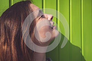 Woman looks at the sun with narrowed eyes