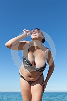 Woman looks on sun through tinted sunglasses