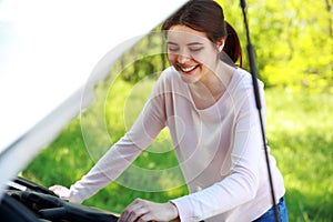 Woman looks under hood car