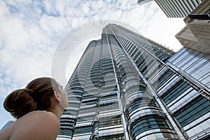 Woman looks up to the top of the skyscrapper