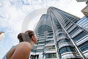 Woman looks up to the top of the skyscrapper photo