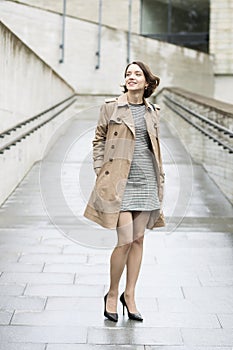 Woman at loose beige coat in good mood