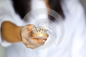 Woman losing hair on hairbrush in hand