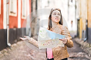 Woman lost in the city. Confused traveler holding map.