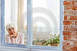 Woman lost in thought by the window photo
