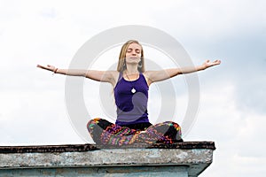 Woman in a lotus pose on the roof