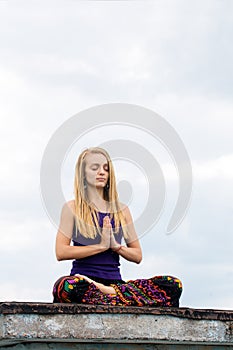Woman in a lotus pose on the roof