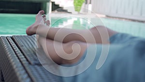 A woman lounging on the edge of a hotel pool in a pausing to rest. Women sleep by their own pool for relaxation. Holiday vacation