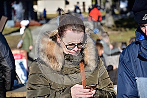 A woman in love looks into her cell phone and sends a text message to her family