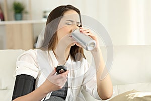 Woman with low blood pressure drinking sweet soda photo