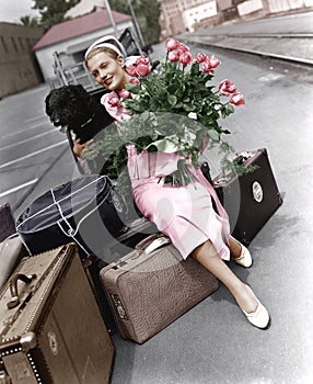 Woman with luggage flowers and dog