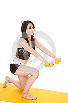 Woman lunging with yellow weights one knee