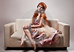 Woman in luxurious dress sitting on sofa