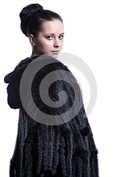 Woman in luxury black color fur coat looking back