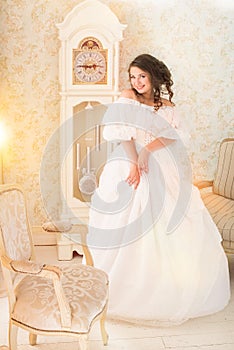 Woman in luxury vintage dress standing in bright room