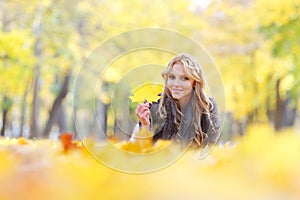 Woman lying in autumn leaves