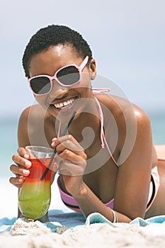 Woman lying at beach while having pineapple