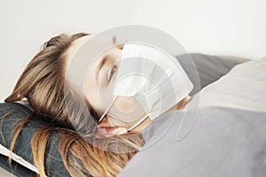 Woman Lying in Bed in Face Mask. Coronavirus COVID-19