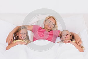 Woman lying in bed with her children