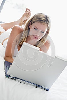 Woman lying in bed with laptop