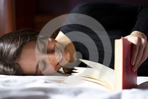 Woman lying in bed and reading a book photo