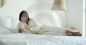 Woman Lying on Bed Texting in the Bedroom