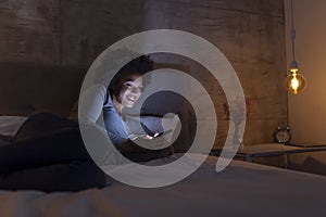 Woman lying in bed typing a text message