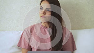 Woman lying on bed using notebook and look at window