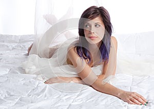 Woman Lying on Bed With White Comforter