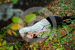 Woman lying on a branch talking on mobile phone