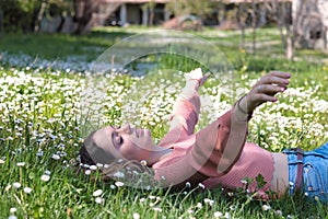 Woman lying on a carper of daisies in a well-being moment