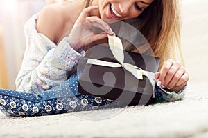 Woman lying on carpet with present