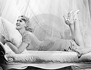 Woman lying on a chaise lounge with her legs up