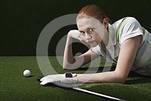 Woman Lying On Course With Golf Club And Ball