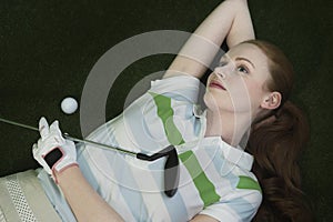 Woman Lying On Course With Golf Club And Ball