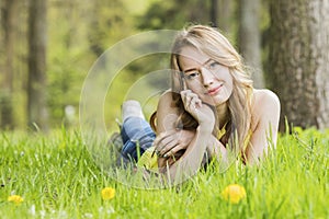 Woman lying on dandelions field