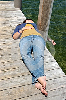 Woman lying on the docklake lakeside.