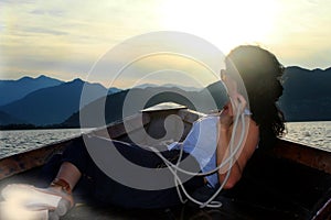 Woman lying down in a boat and looking into the distance