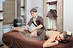 A woman lying down doing cryolipolysis treatment.