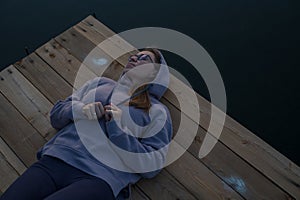 Woman lying down on the pier at lake