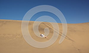 The woman lying on the dunes under a scorching sun