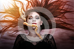 Woman lying on the floor with eyes closed, face the snake slither-awesome