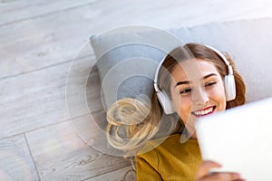 Woman lying on the floor and listening to music