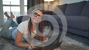 Woman is lying on the floor and makes an online purchase using a credit card and laptop. Online shopping, lifestyle