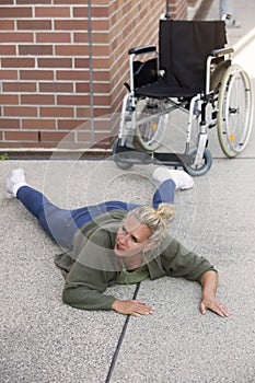 Woman lying on floor next to wheelchair