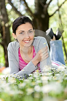 Woman lying on the grass with flowers