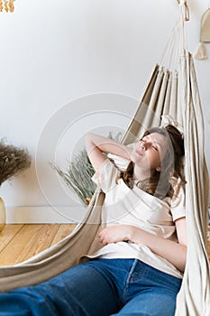 A woman lying in a hammock. Relax on women& x27;s day. Life is on pause. Rest after a hard day