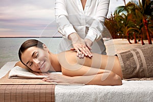 woman lying and having back massage at spa