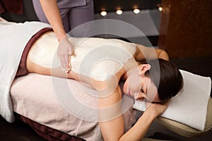 Woman lying and having back massage at spa
