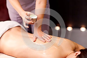 Woman lying and having back massage at spa